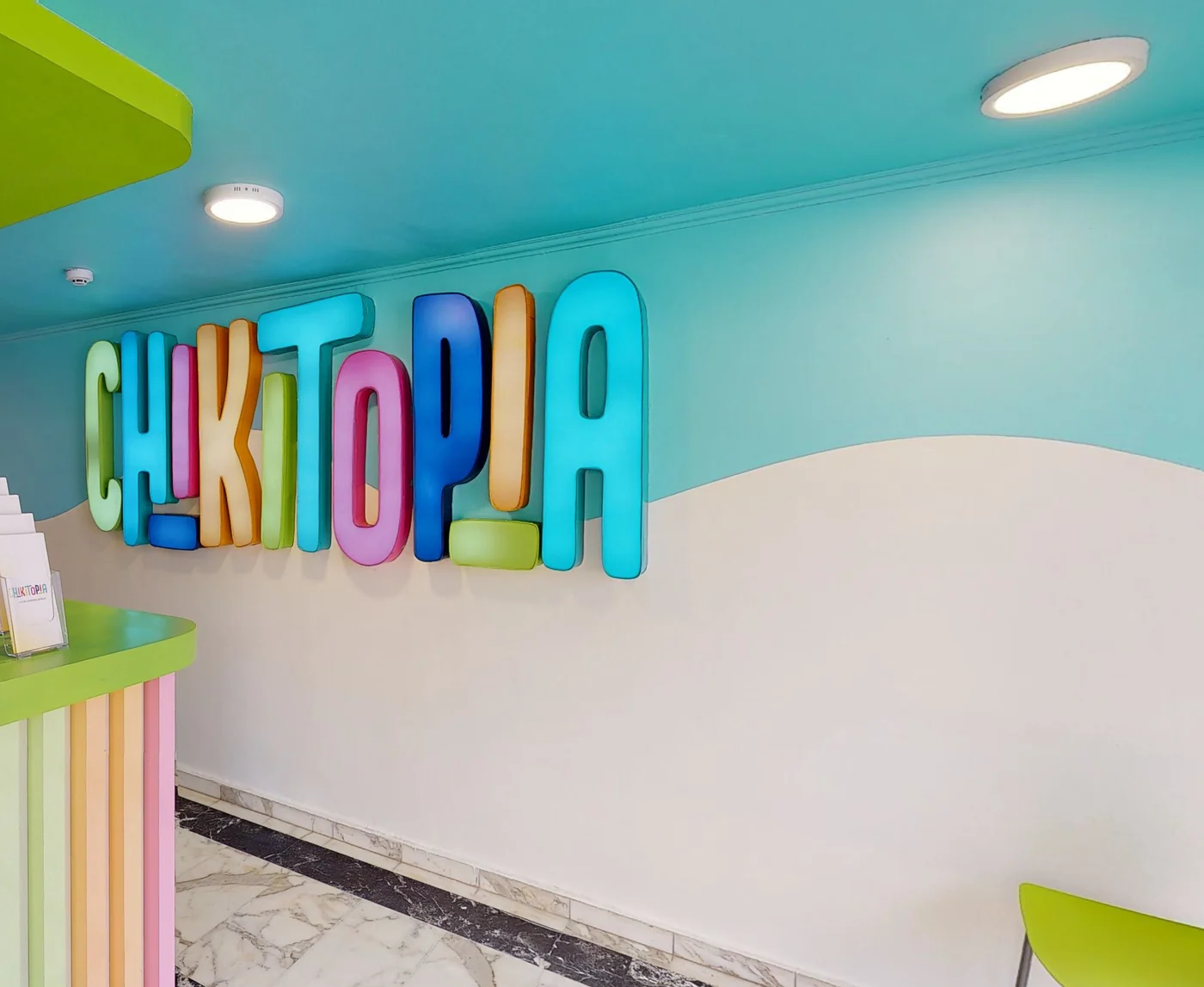Niño explorando un panel de actividades de madera en Chikitopia